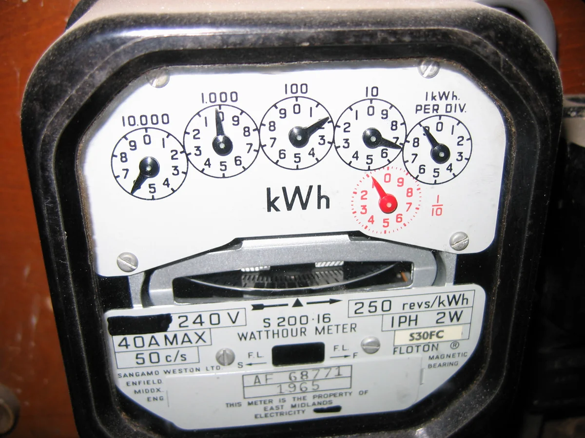 Close-up photograph of a mechanical electricity meter with multiple numbered dials and a kWh display.