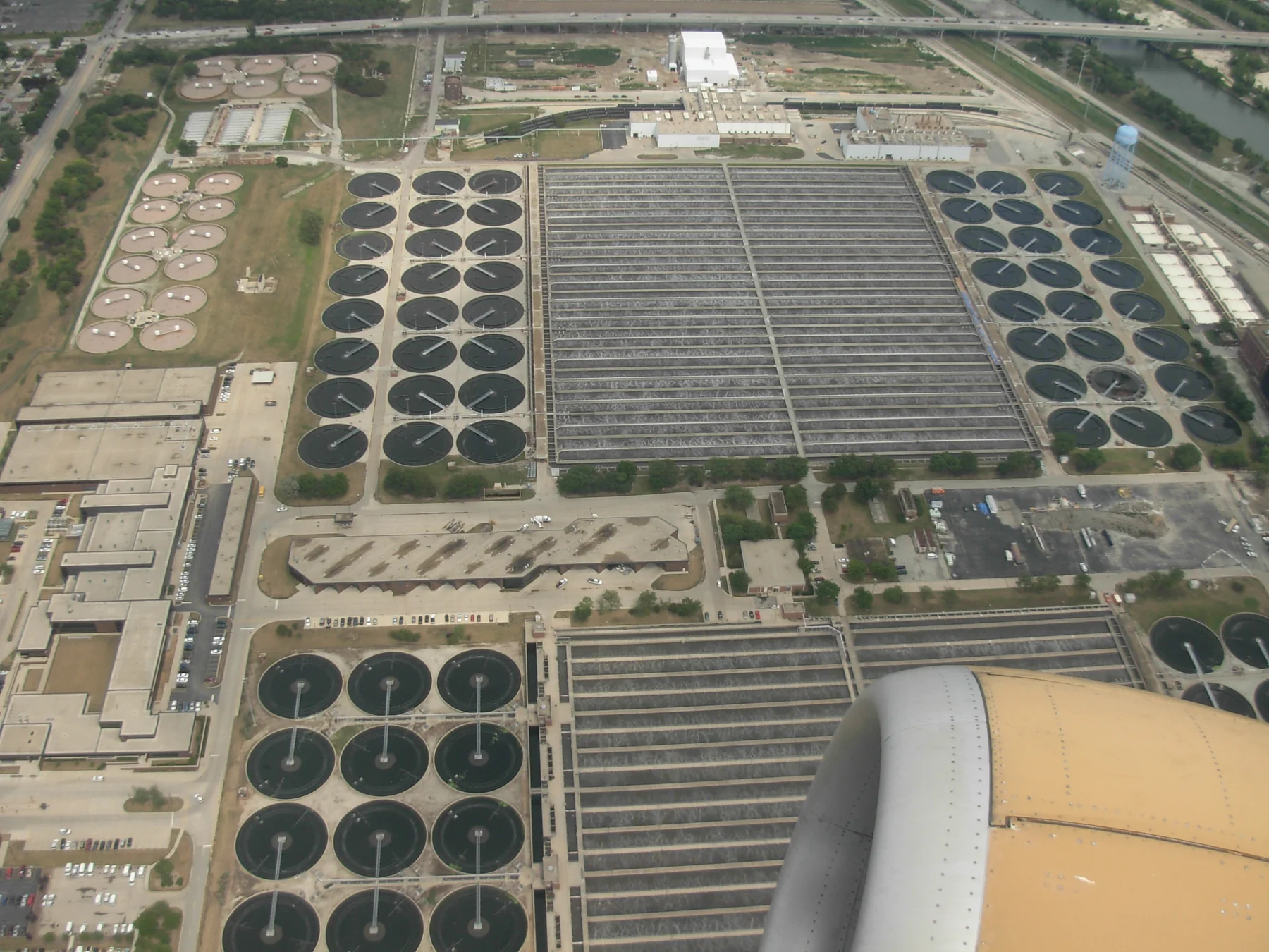 Aerial view of the Stickney Water Reclamation Plant, showing many circular treatment basins and rectangular processing areas across the facility.