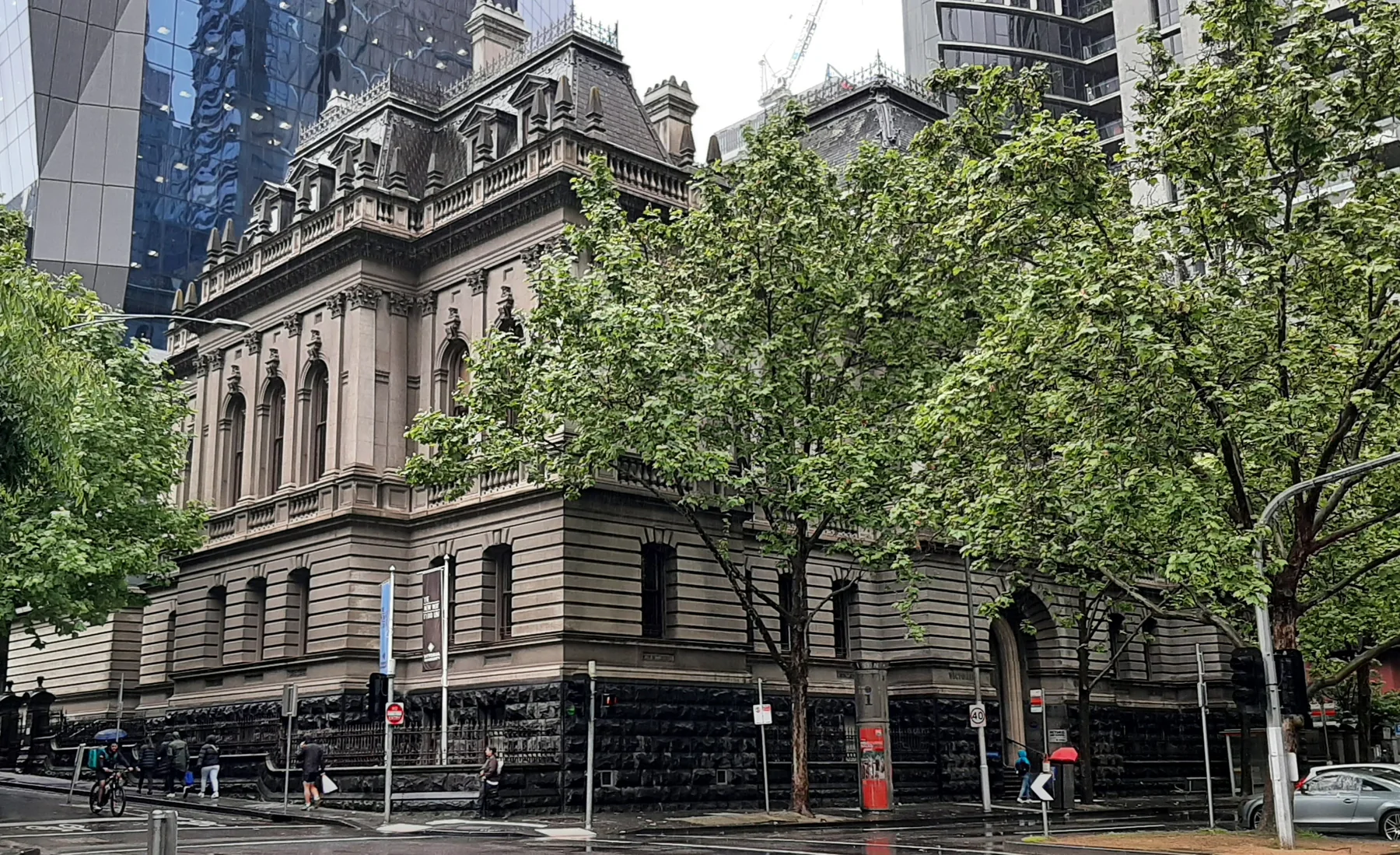 Landscape photograph of the former Records Office heritage building, viewed from across a paved area with trees and street furniture.