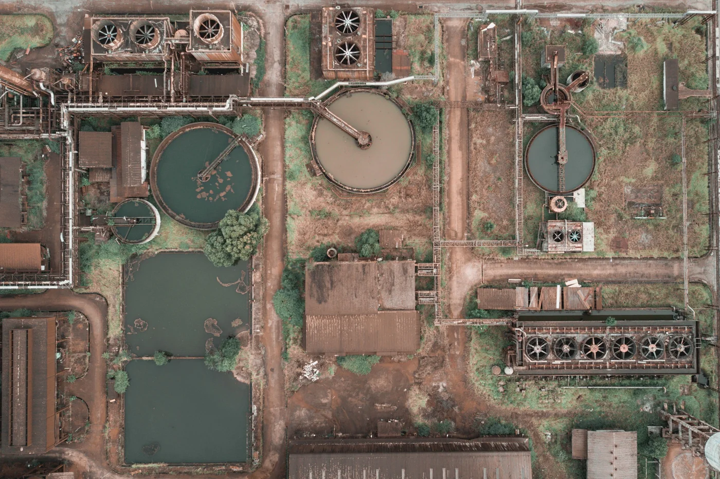 Aerial view of a wastewater treatment plant with circular clarifiers and tanks.