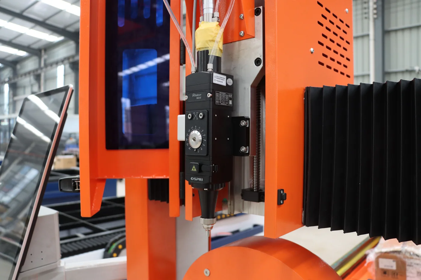 A CNC machine head and surrounding industrial equipment.