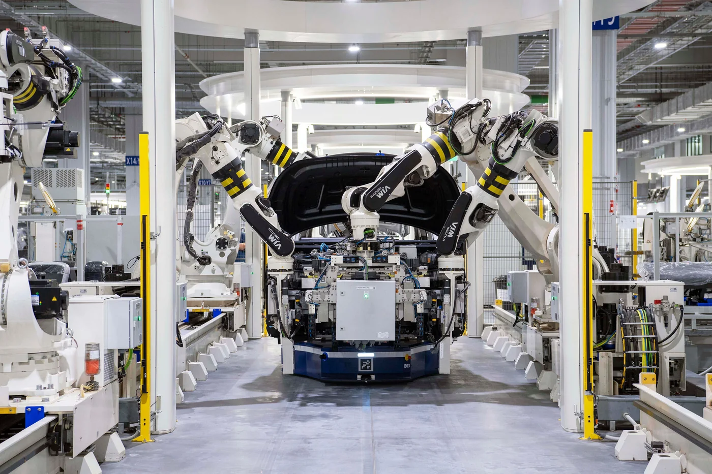 Industrial robots assembling a vehicle body on an automotive production line.